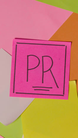 Vertical-Video-Business-Concept-Of-Revolving-Sticky-Notes-With-PR-Written-On-Top-Note-1